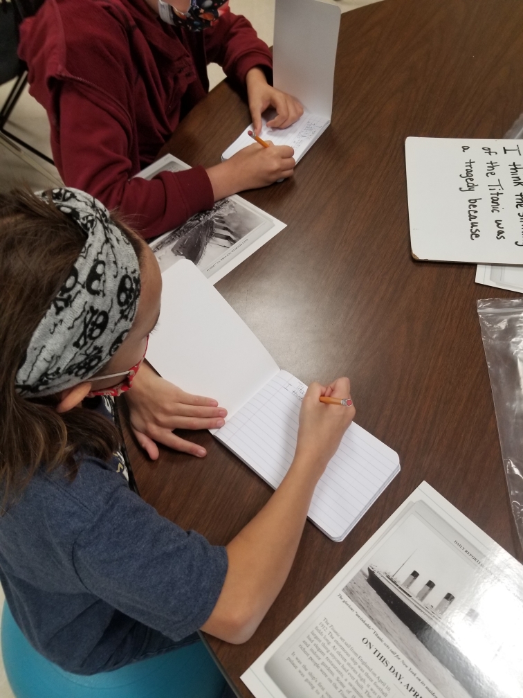 Student writing in a notebook.