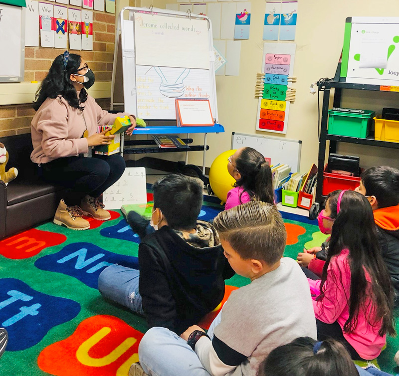 Students Sitting on Carpet Learning from Teacher