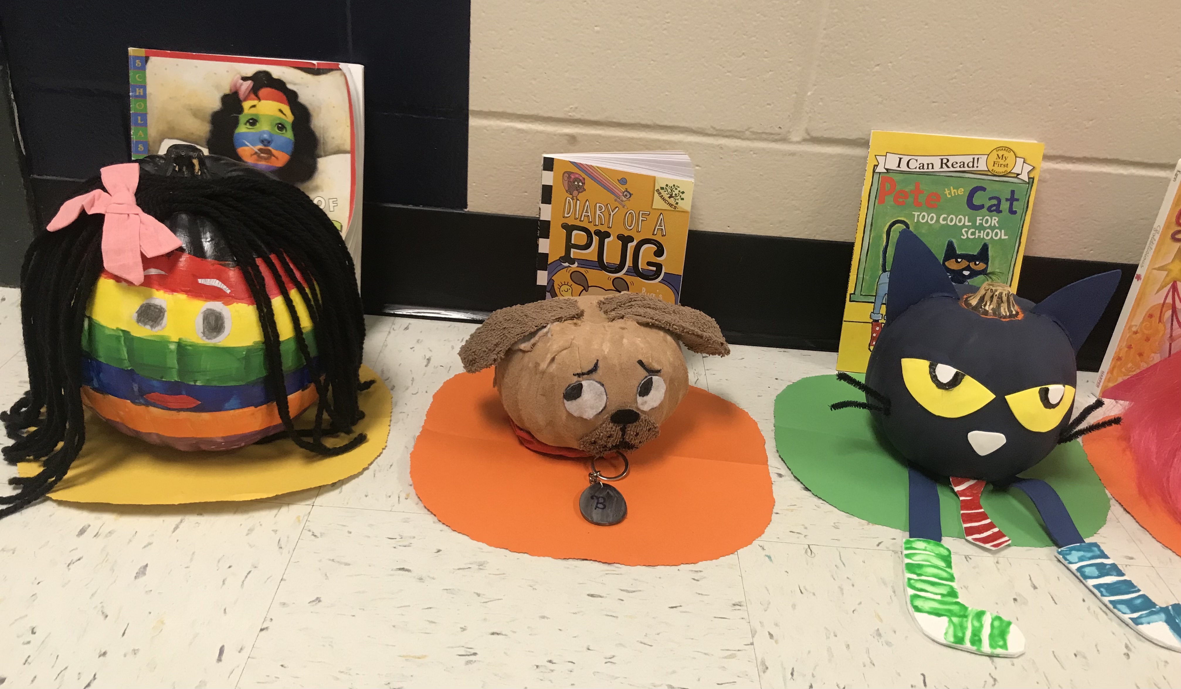 Pumpkins decorated like a rainbow face, pug and Pete the Cat