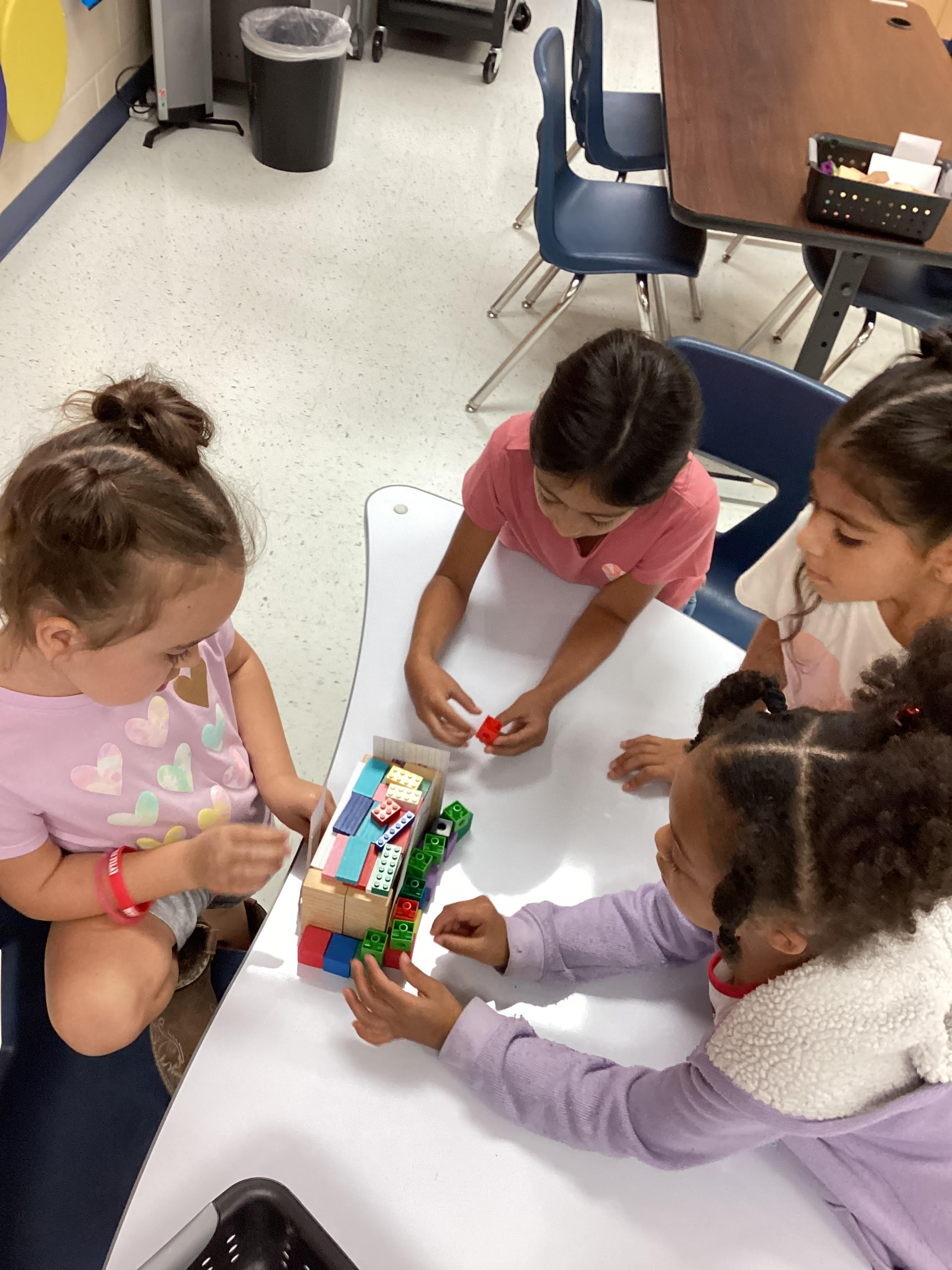 Kids using their imaginations using legos while in STEM Class