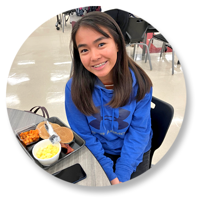 Student sitting at table with lunch tray