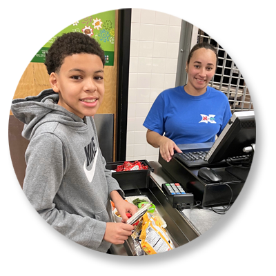 Student paying for lunch at the school cafeteria register.
