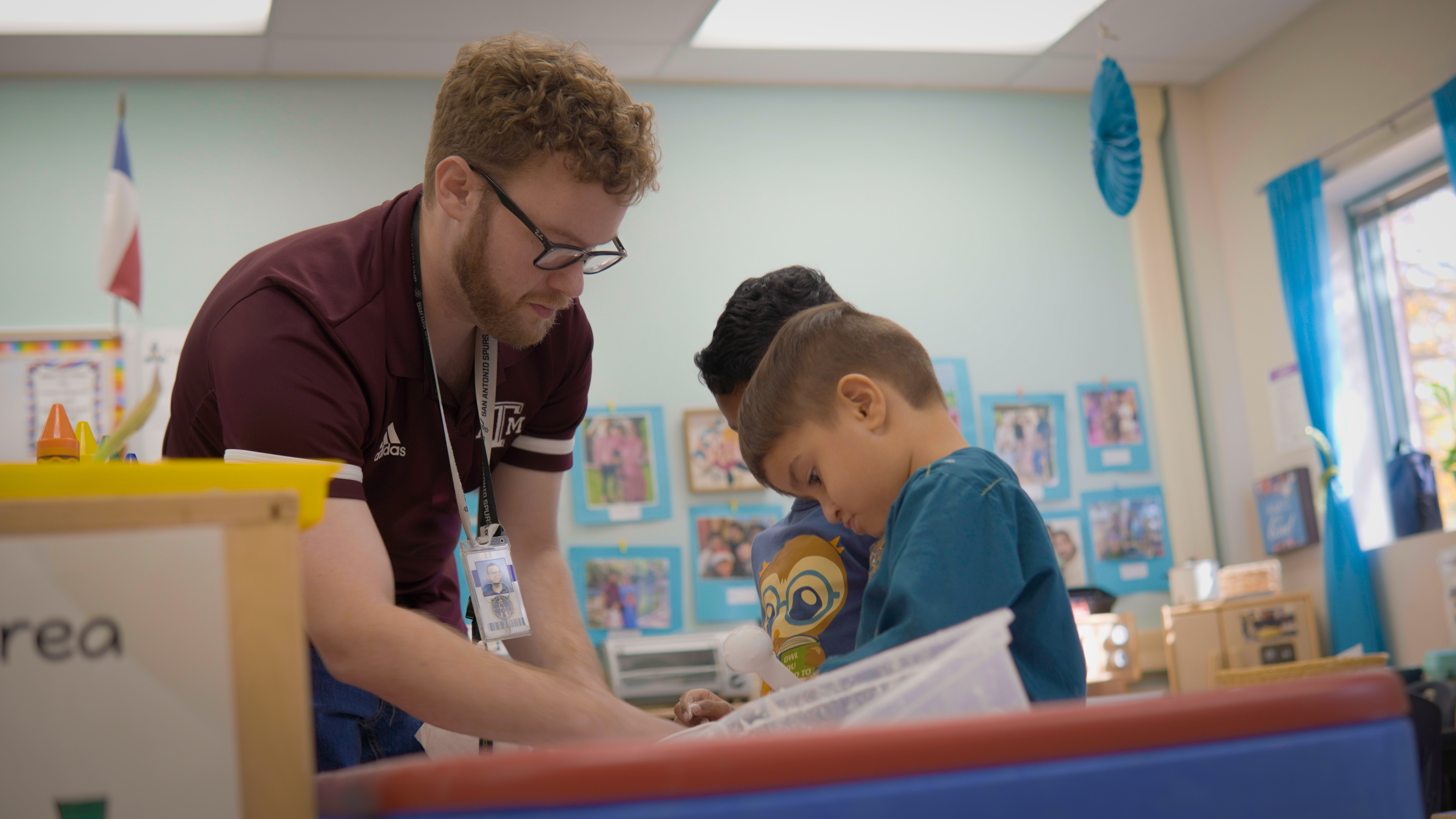 One of our Pre-K Instructional Assistants, Mr Steele, helping students at a learning station