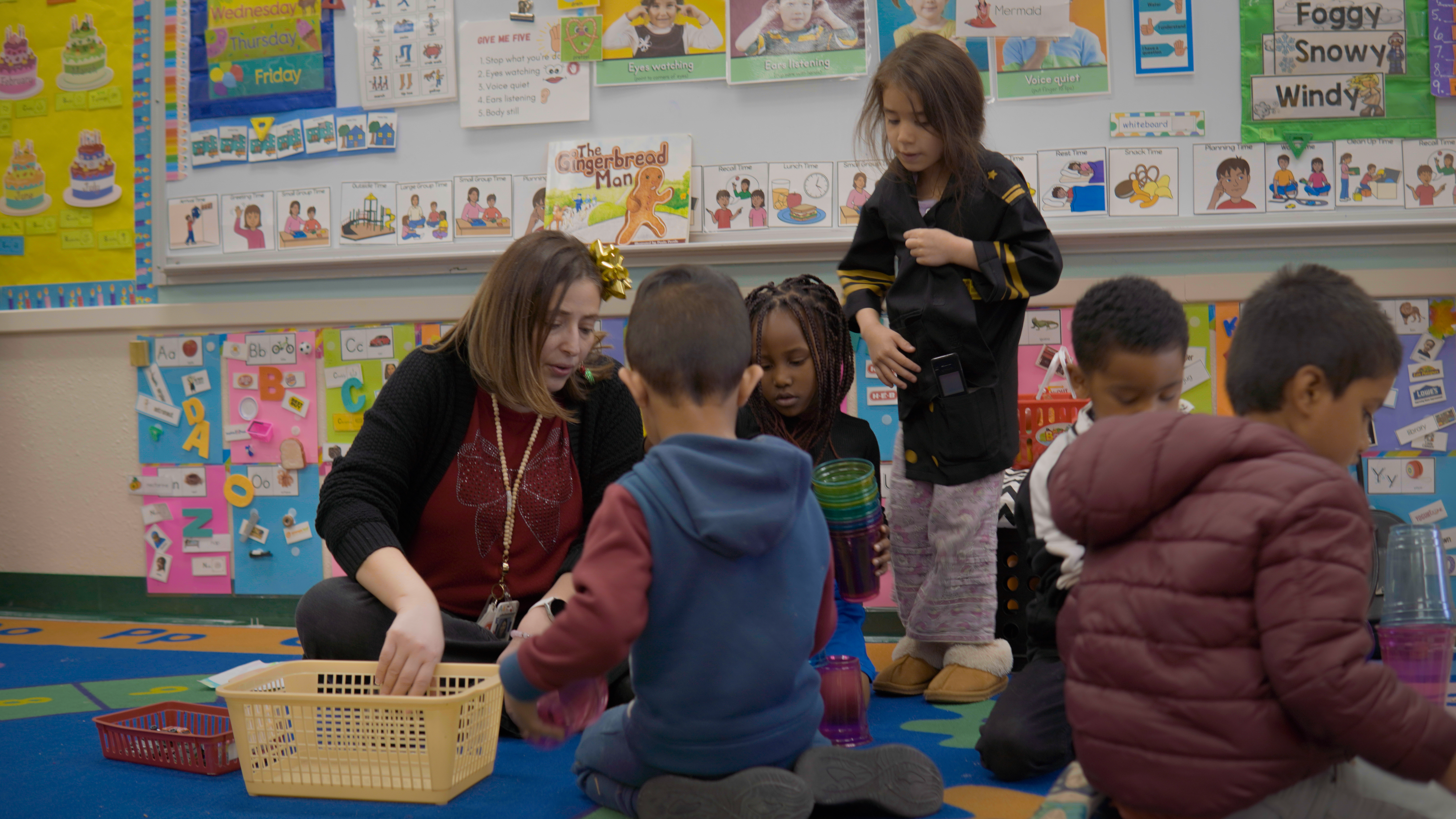 Our Pre-K team lead, Mrs Chebly sitting on the floor with her students