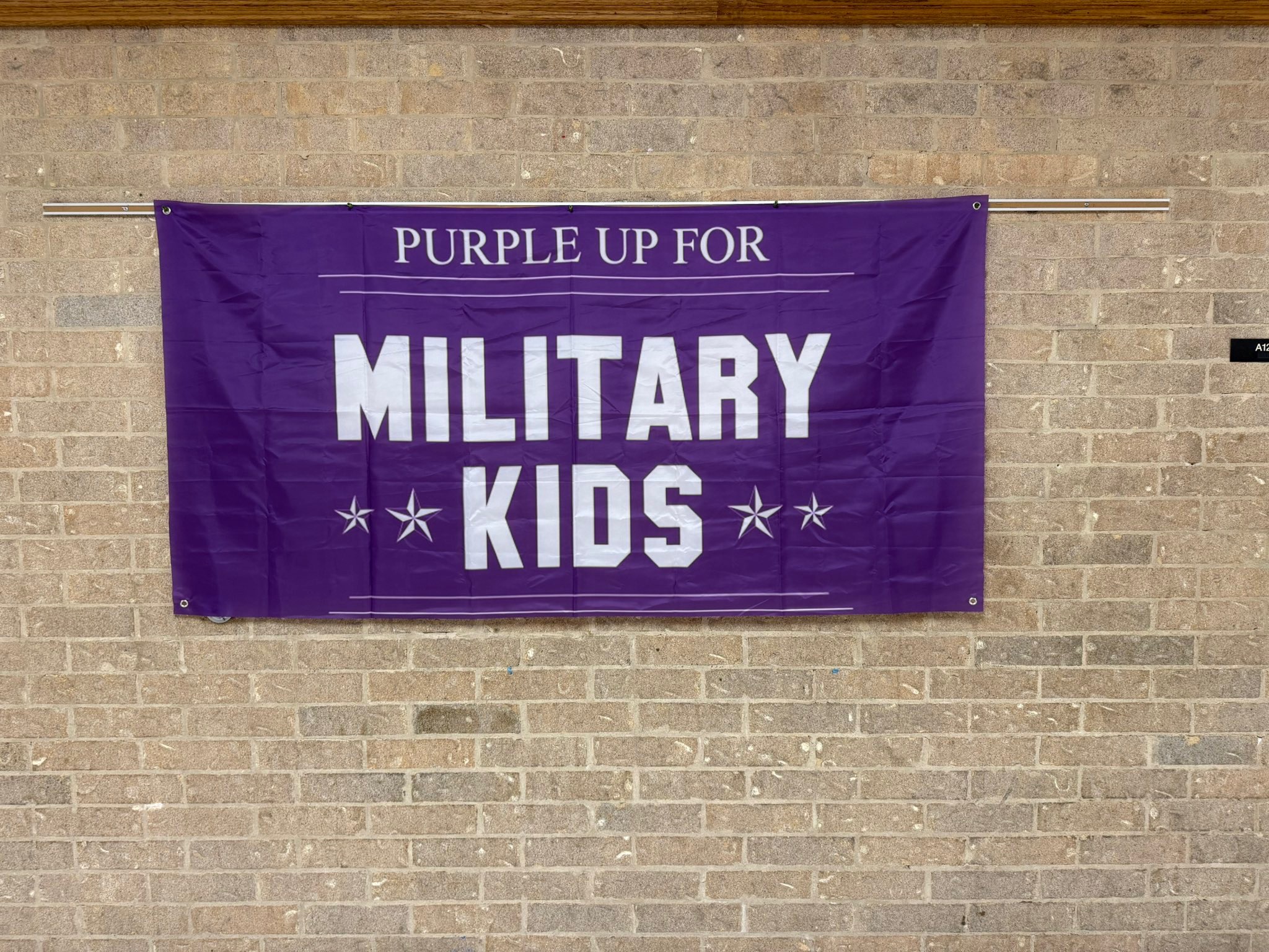 Picture of purple flack on brick wall that says Hobby MS supports Military Families