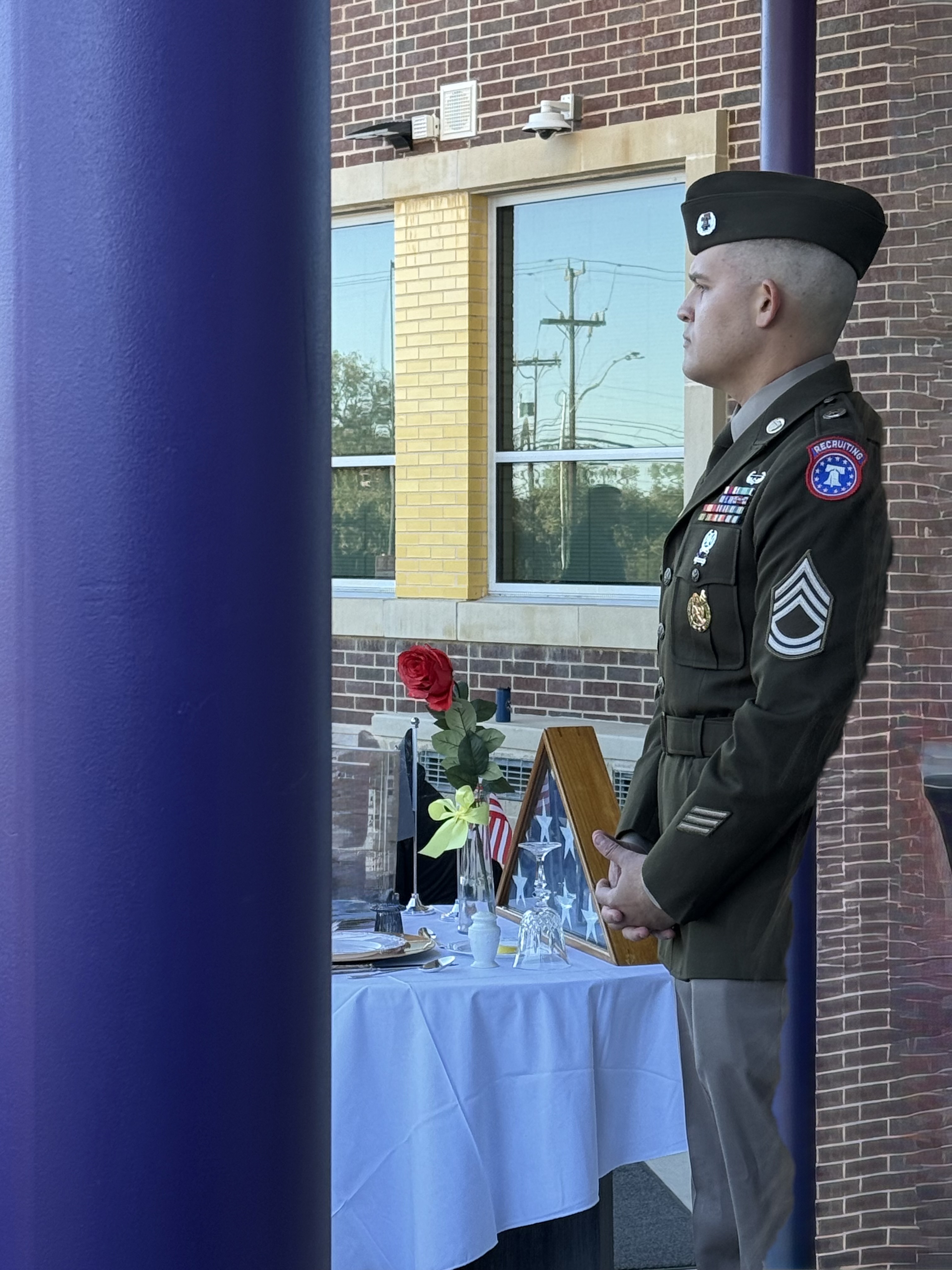 picture of soldier standing by table with american flag and candles