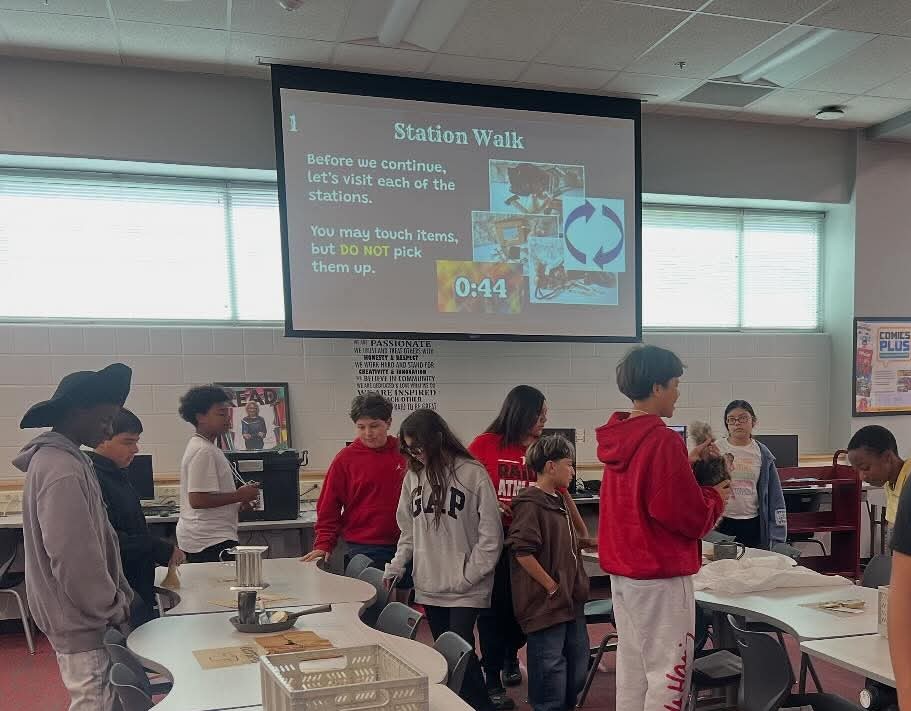 Students sitting at a table engaging with hands-on activities from the Alamo History Trunk