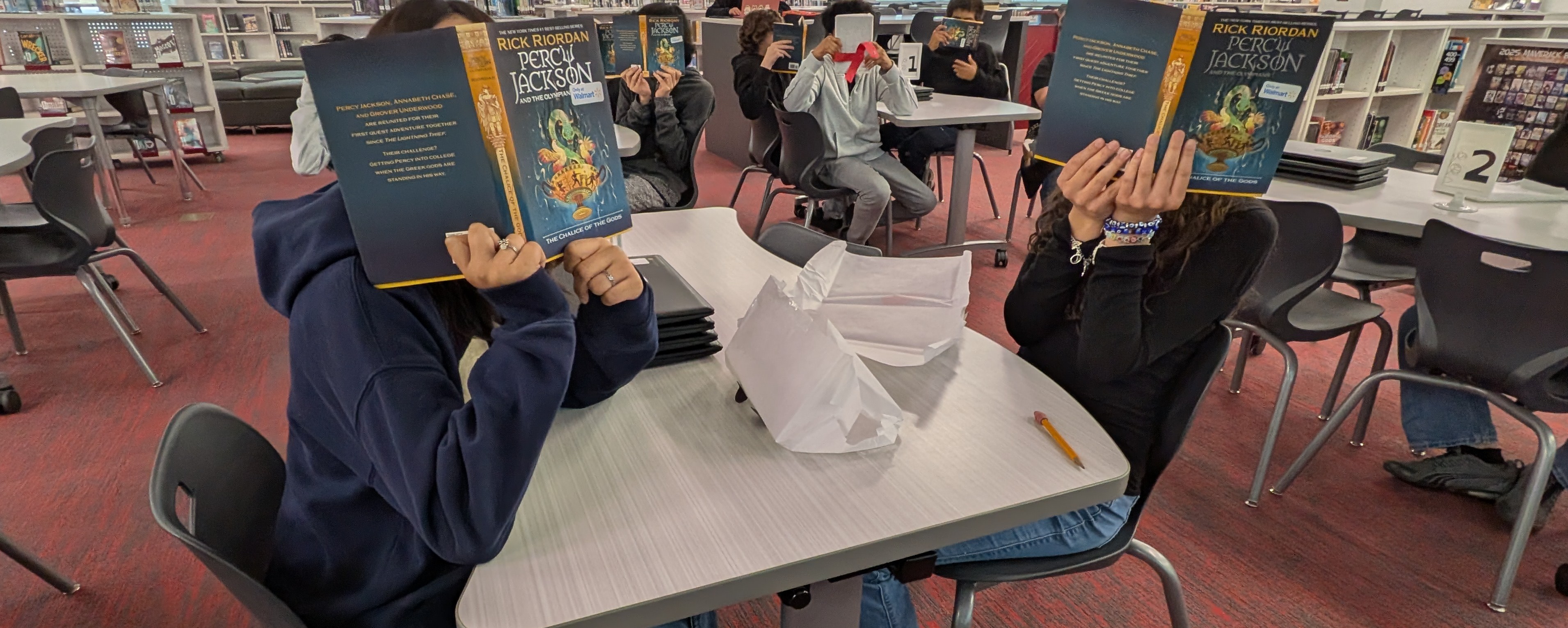 students hold books they were gifted during a giveaway