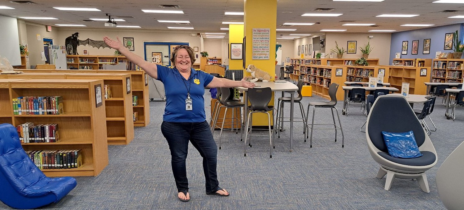 Mrs. Kaster celebrates our recently renovated library with new carpet, paint and, extra space for fun furniture.