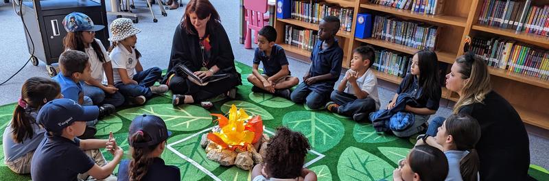 Photo of children sitting with Mrs. Grimes in library