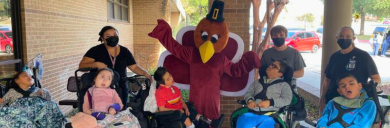 Reddix Staff and Students posing with a someone in a turkey costume