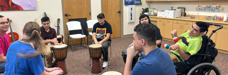 Reddix students sitting around in a circle playing the drums