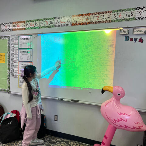 Cardboard arcade student demonstating her design.