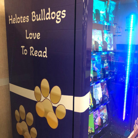 Left side of Book Vending Machine with "Helotes Bulldogs Love To Read" quote and bulldog paws