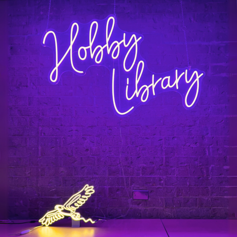 Neon sign that reads Hobby Library and a neon hawk underneath it