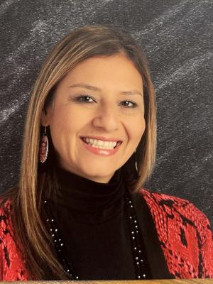 Female Principal with sandy blonde hair wearing a red suit coat and black shirt.