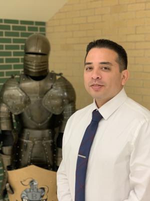 Principal Jose Mendez in front of black knight