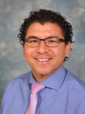 Portrait of Pete Pruneda with a grey background.