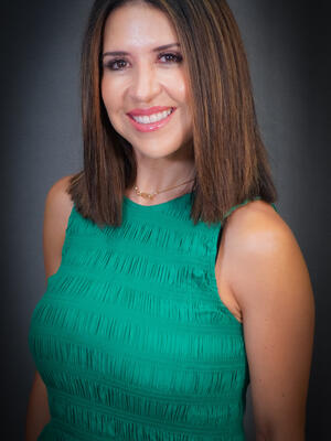 Principal Espinoza smiling wearing a green dress.